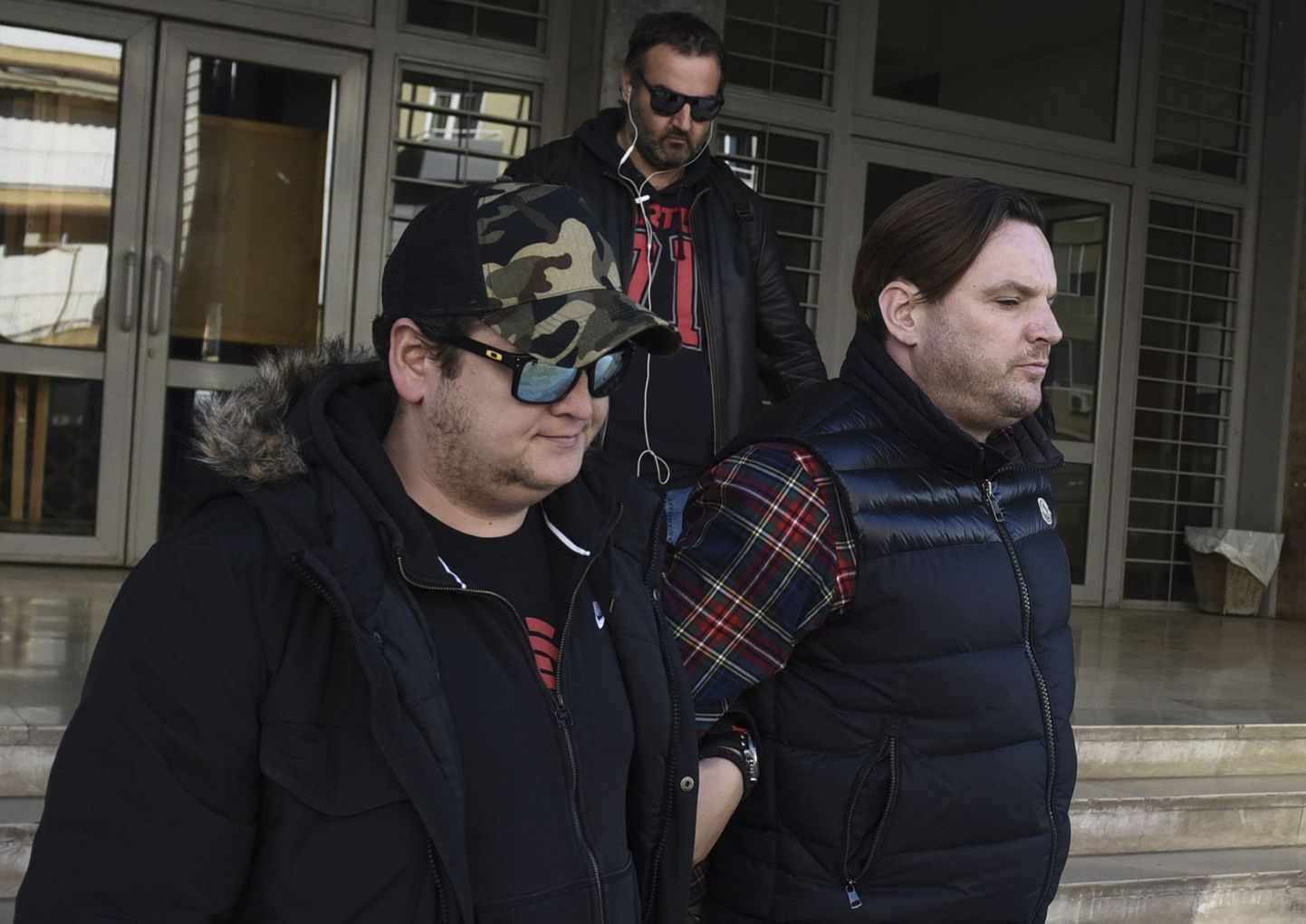 Politsei poolt eskorditud 39-aastane Simon Dutton (paremal) väljumas Thessaloniki kohtumajast.