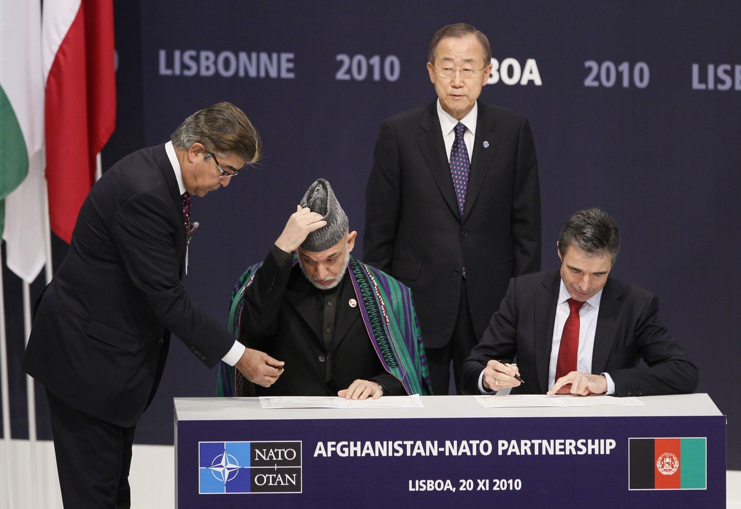 Afganistani president Hamid Karzai ja NATO peasekretär Anders Fogh Rasmussen allkirjastamas ÜRO peasekretäri Ban Ki Mooni pilgu all kahepoolset koostöölepet.