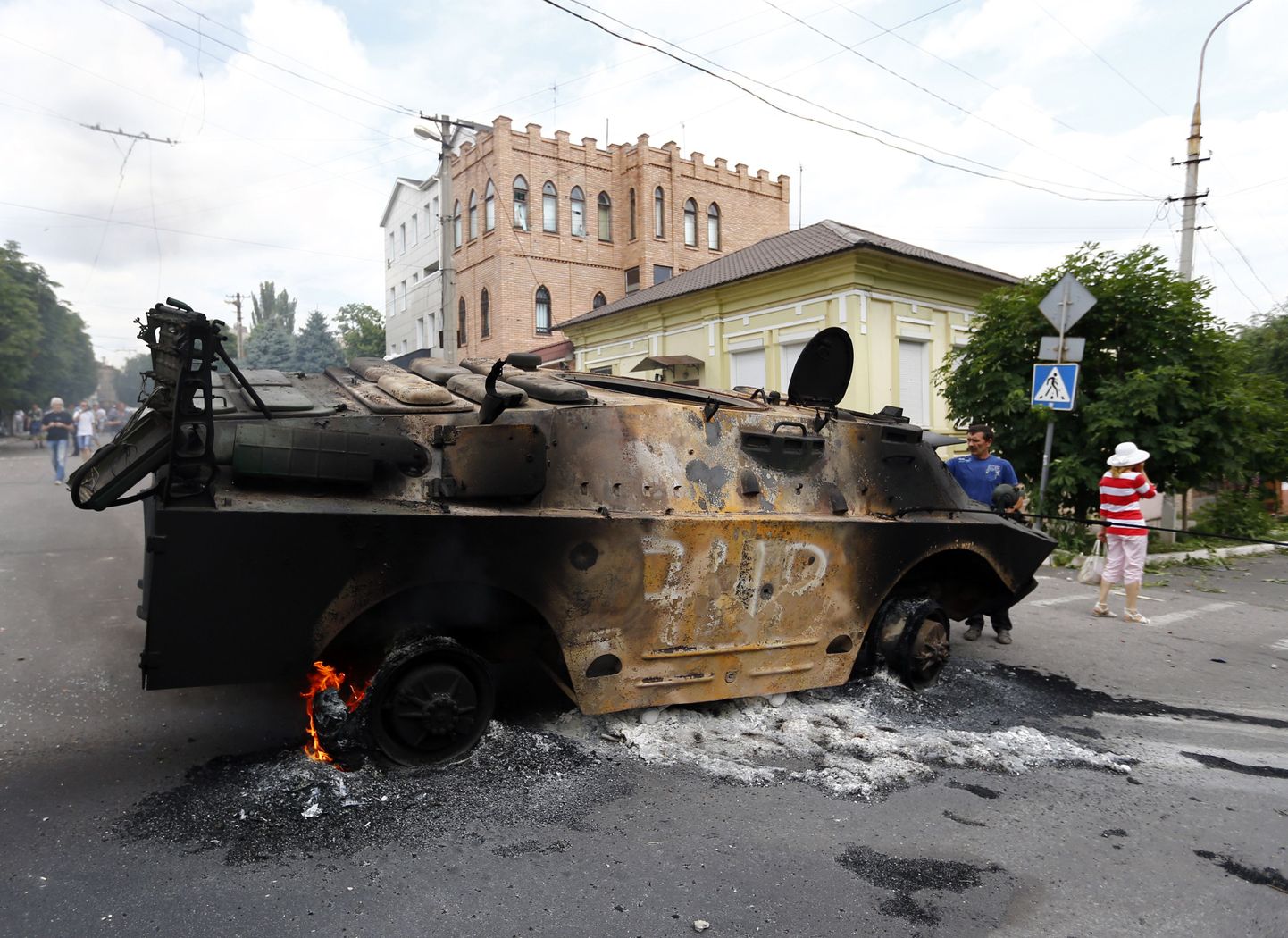 Kohalikud elanikud uurivad Mariupolis nn Donetski rahvavabariigi soomukit, mille hävitasid Ukraina relvajõudude sõdurid.