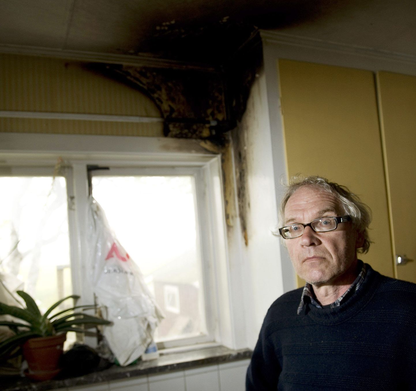 Lars Vilks täna oma põletada saanud köögiakna ees.