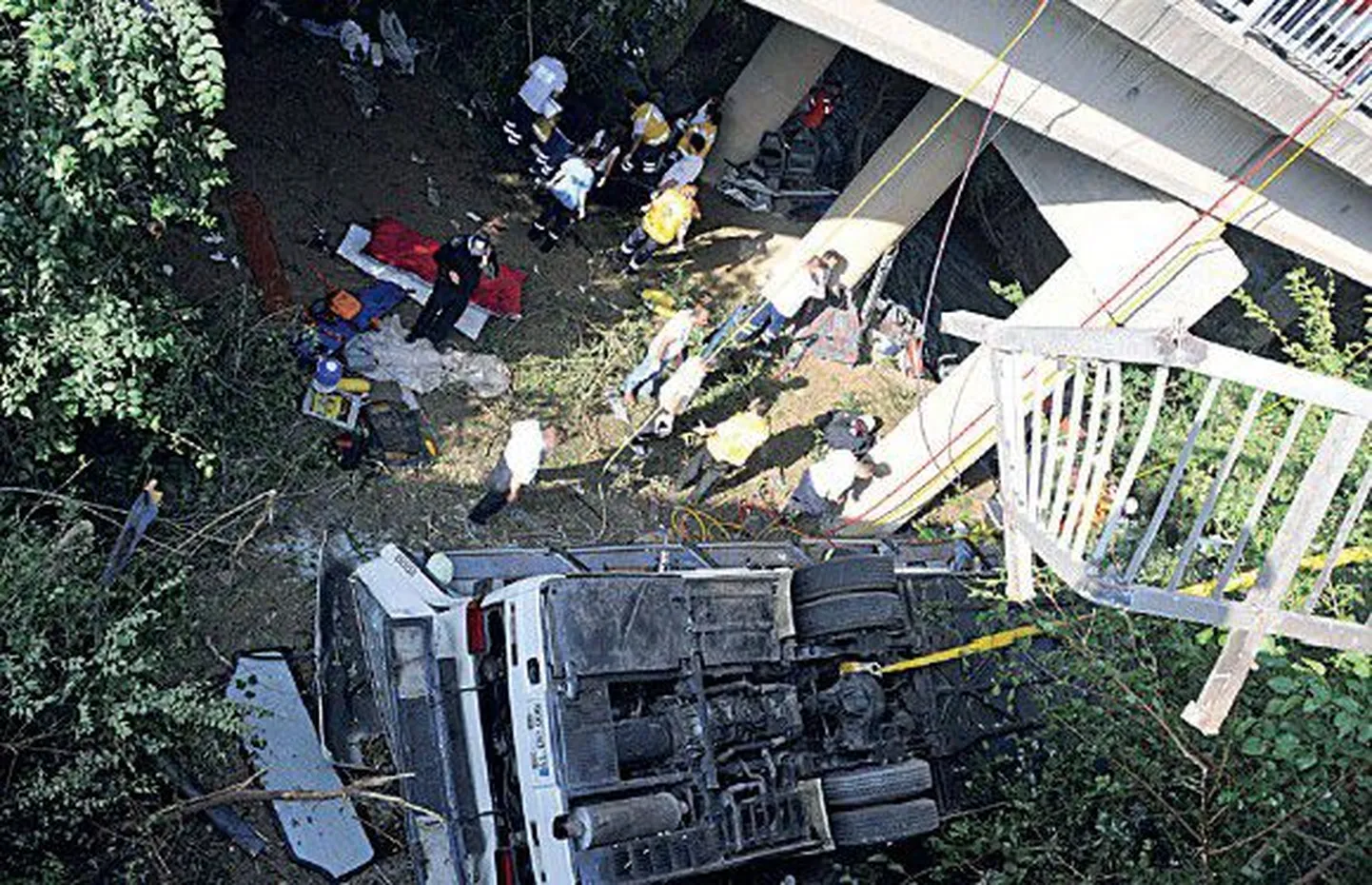 Спасательные работы на месте аварии. Упавший с моста автобус приземлился на крышу.