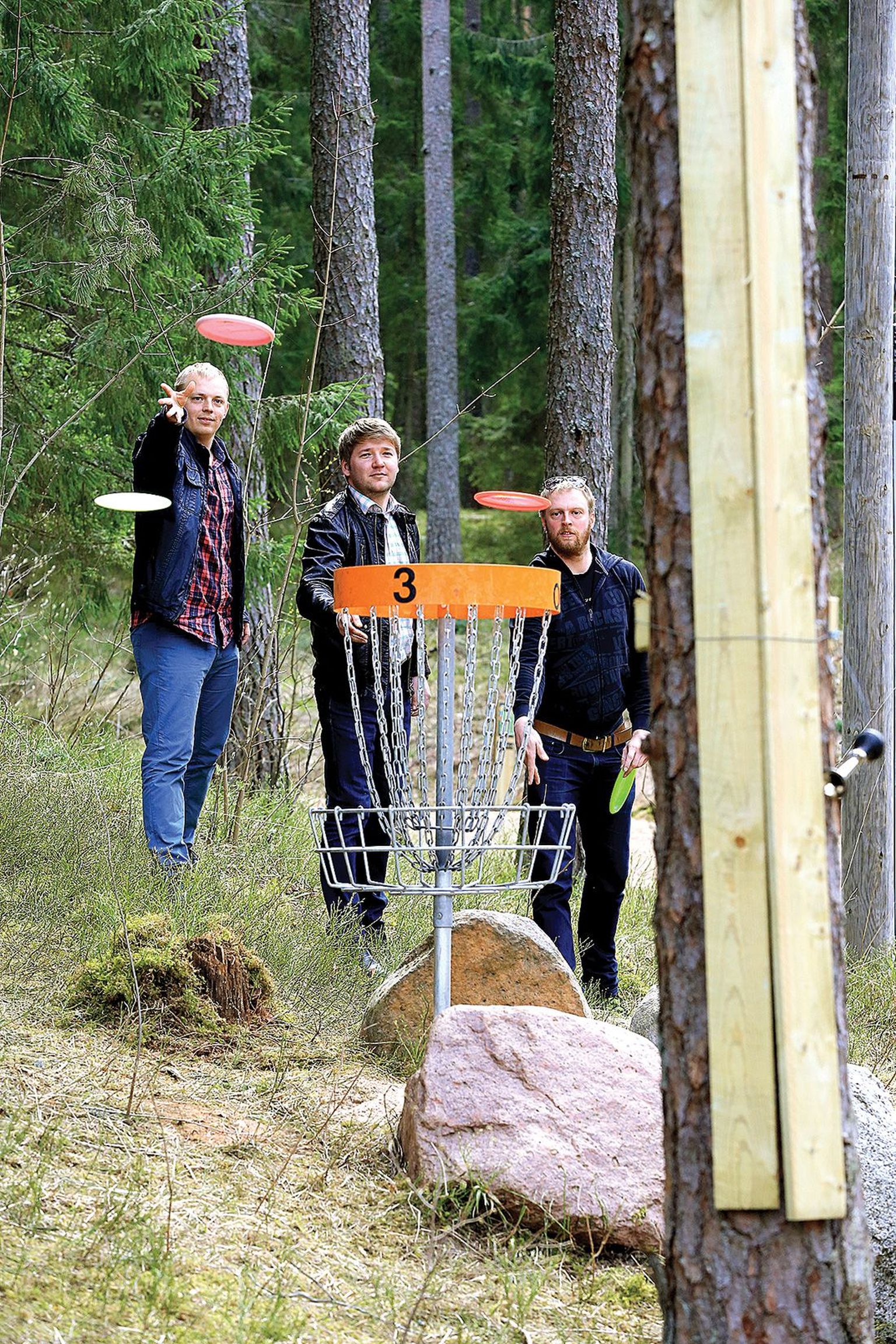 Et kaitsta korvide ääres kasvavate puude koort, paigaldasid Vooremäe taldrikugolfiraja meistrid Tanel Mehine (vasakul) ja Ergo Leibak (paremal) puude ümber lauad. Koos vallavanem Priit Lombiga katsetati viskekätt raja kolmanda korvi juures.
