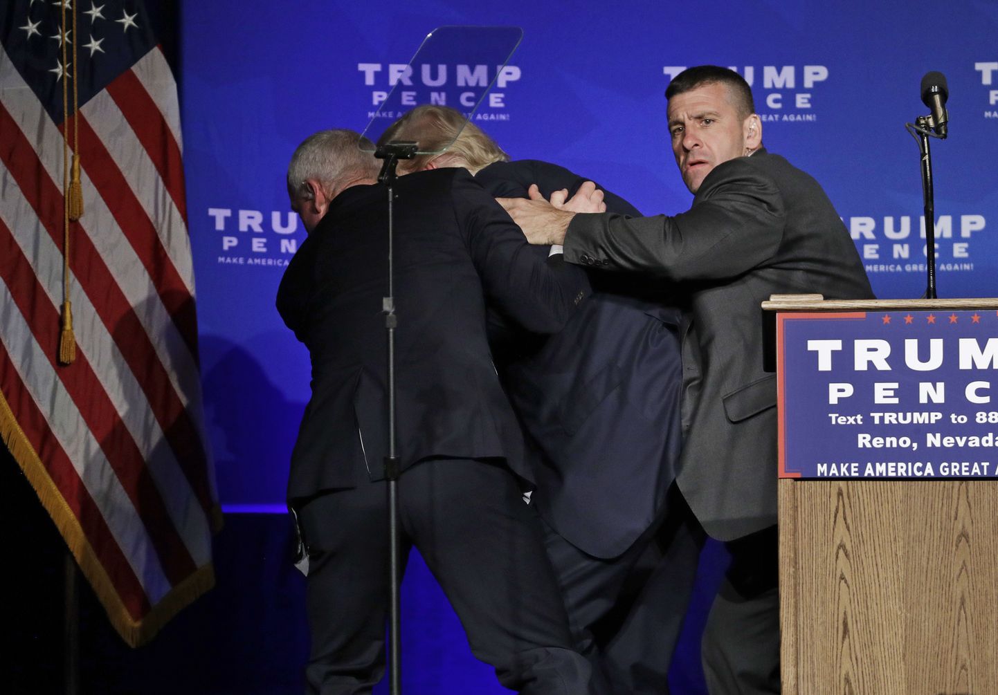 Secret Service agents rush Republican presidential candidate Donald Trump off the stage at a campaign rally in Reno, Nev., on Saturday, Nov. 5, 2016. (AP Photo/John Locher)