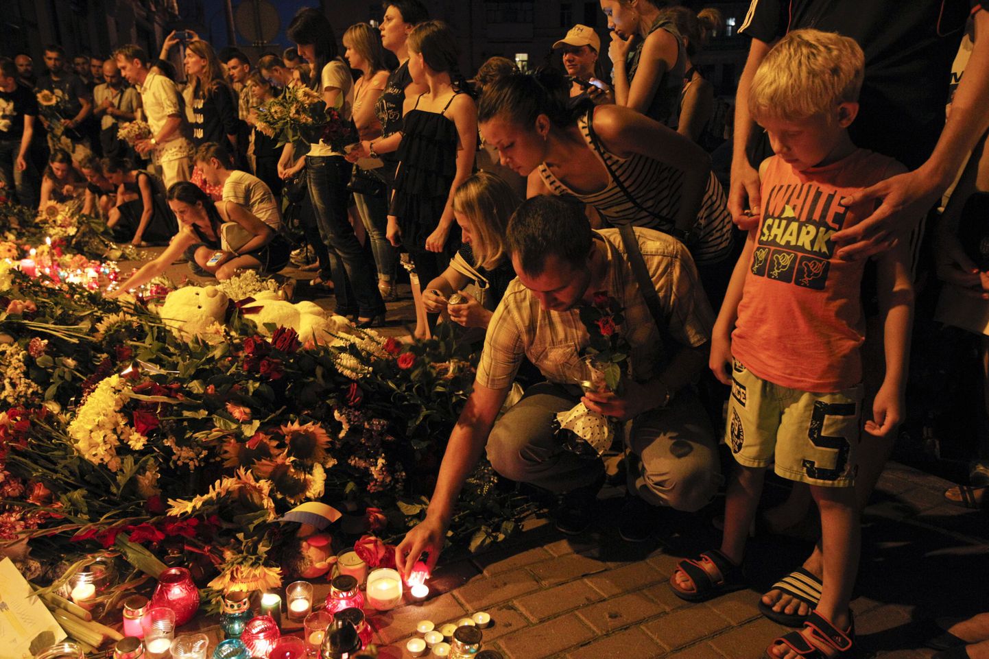 Украинцы приносят свечи и цветы к посольству Нидерландов, полторы сотни граждан которых стали жертвами катастрофы авиалайнера.