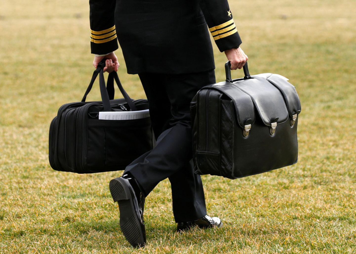 Американский моряк несет ядерные чемоданчики во дворе Белого дома.