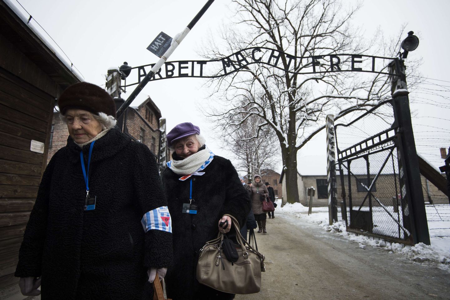 Ellujäänud endise Auschwitzi koonduslaagri värava «Töö teeb vabaks» juures Poolas 27. jaanuaril.
