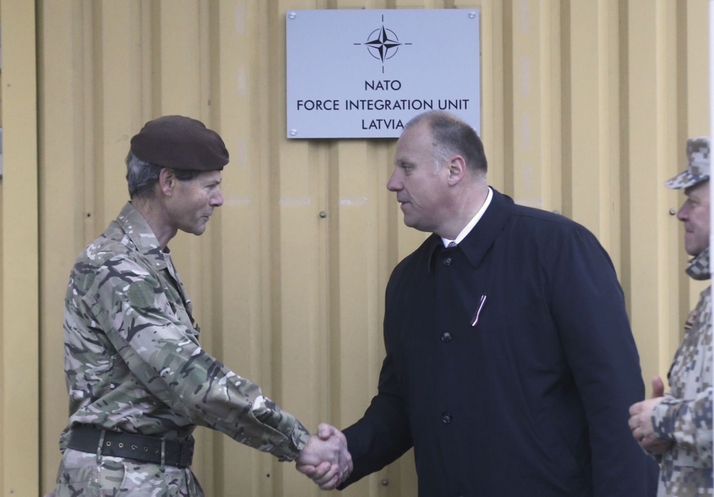 Kõrge NATO ohvitser Adrian Bradshaw (vasakul) surumas kätt Läti kaitseministri Raimonds Bergmanisega.