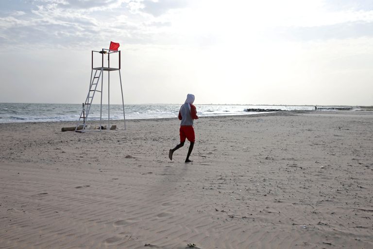 Gambia. Mees Bakau rannas sörkimas. 