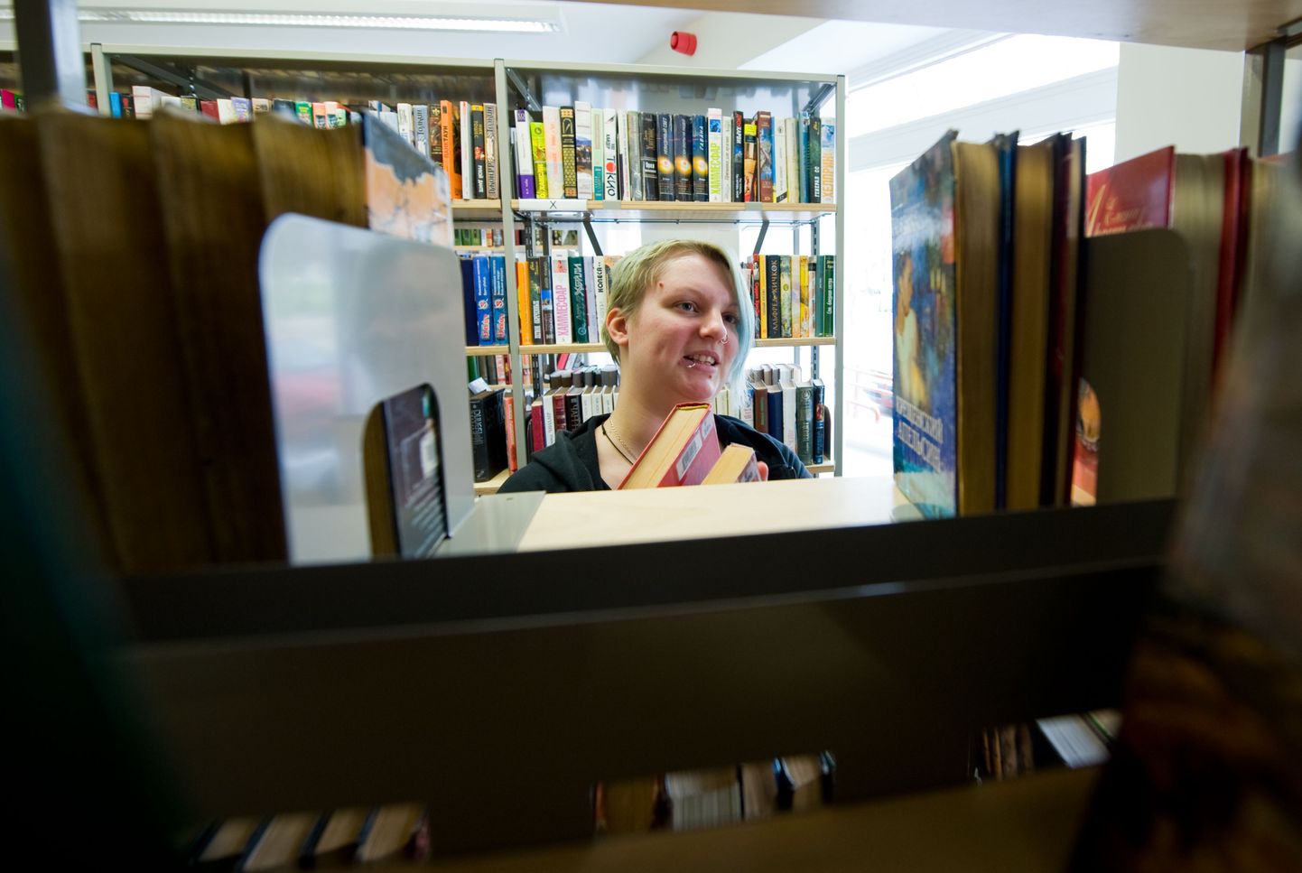 Keskraamatukogu Pelgulinna haruraamatukogu lugemissaali töötaja Annike Redi näitab, et riiulitel haigutavad tühjad kohad, sest lugejad ei ole raamatuid õigel ajal tagasi toonud.