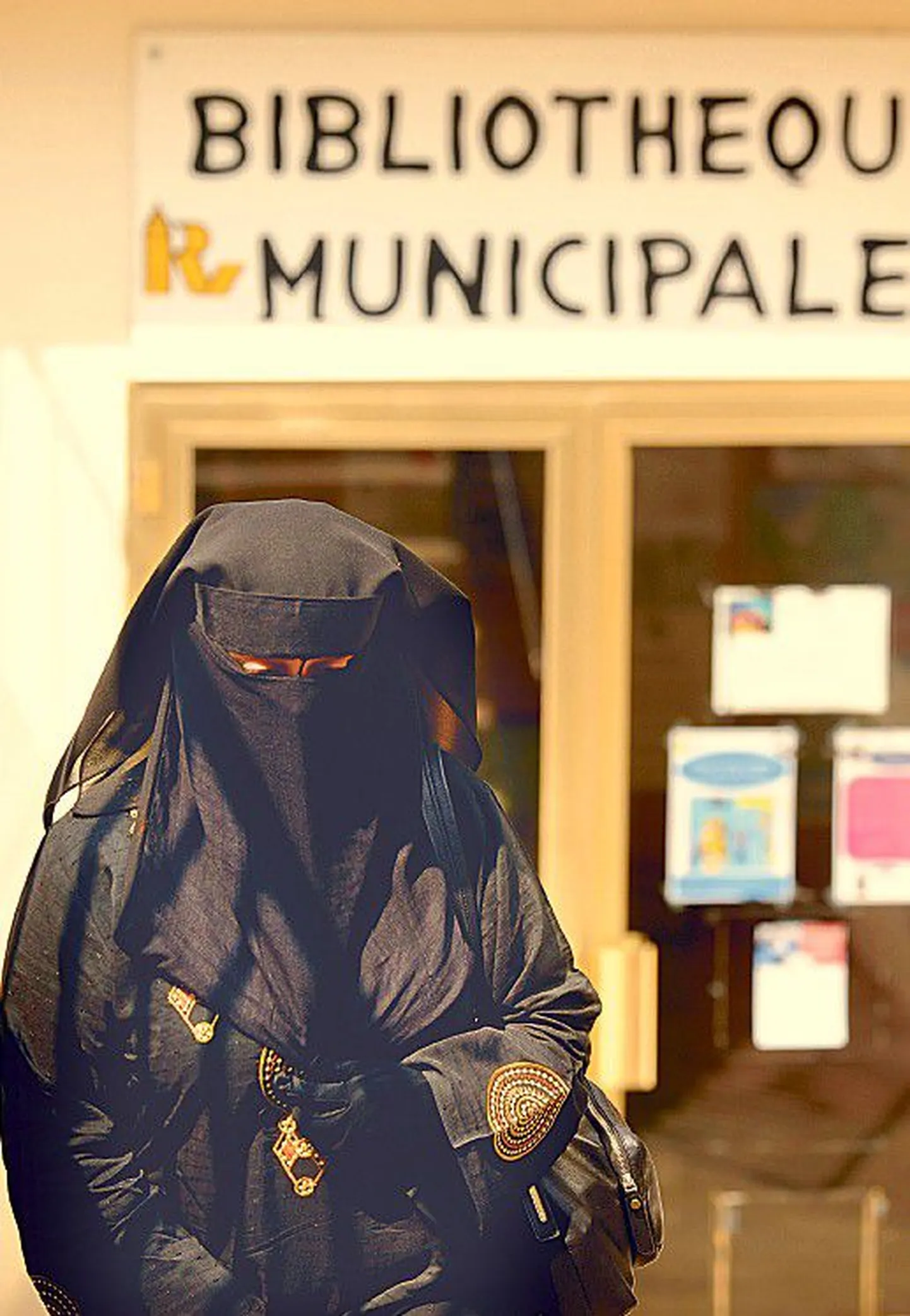 Женщина в никабе перед городской библиотекой в города Роншен на севере Франции.