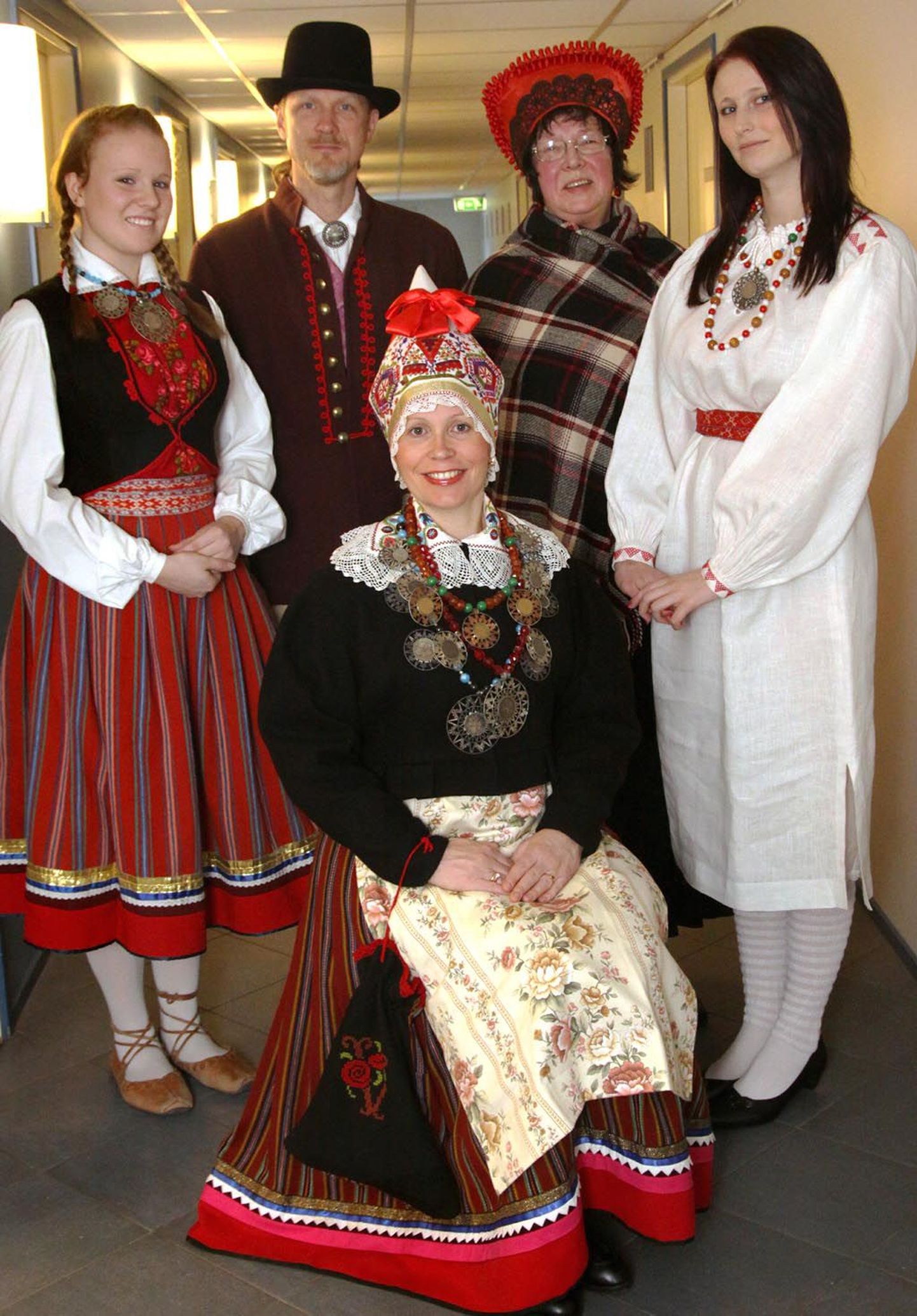 Dagmar Übner (seisab vasakul) kannab 19. sajandist pärinevat punast seelikut ja liistikut (vesti), kaelas aga ehteks kolme "tsaarikollaga" paatrit. Enn Rand esitleb Tõstamaa rõivaid. Suurrätikut ja kabimütsi kandev Marvi Volmer ütles, et Pärnul oma meesterõivaid õieti polegi, mistap on siinsetel meestel lubatud kommet rikkumata kanda nii Audru, Tõstamaa kui Mihkli kihelkonna rõivaid. Paremal seisev Mariliis Kaul on valges pikas särgis, mis on naise igapäevane tubane või suvine rõivas, kuid kireva vöö ja ehetega hõlpsasti pidulikumaks muudetav ja pilkupüüdev. Pildil ees istuv Maria talu perenaine Riina Rand on Pärnu naiserõivaste hiilguses, kus kolm paatrit kaelas ja imeilus kaugelt toodud puuvillasest riidest ja kallis põll rõhutavad emanda jõukust. Peened on ka tikandid, madarapunase pikitriibuga seelik, käekoti ornament.