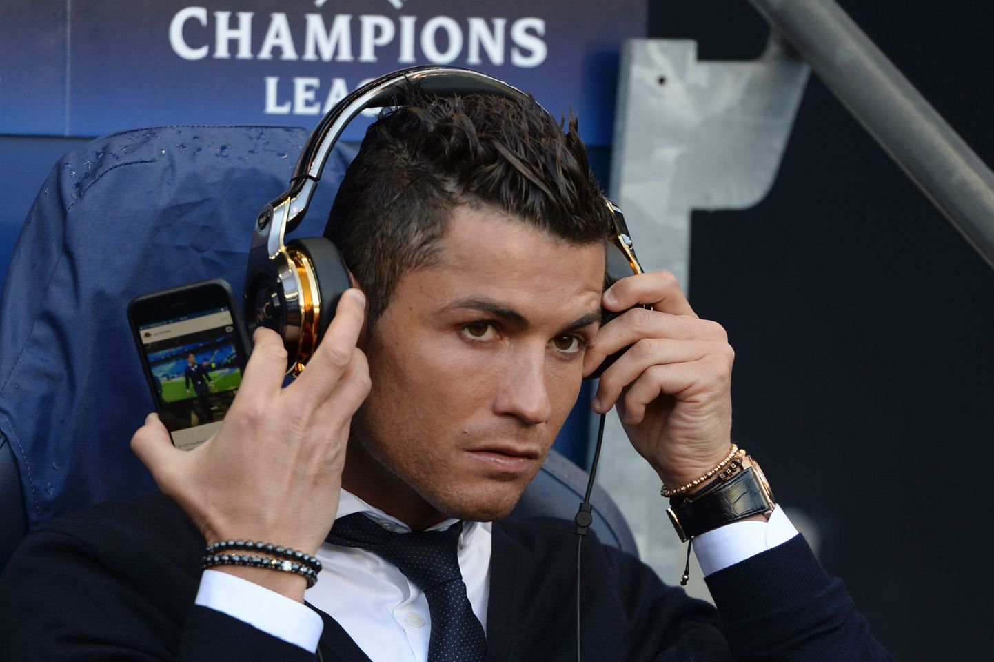 Cristiano Ronaldo istumas eilse mängu ajal tribüünil ja vaatamas endast videot.