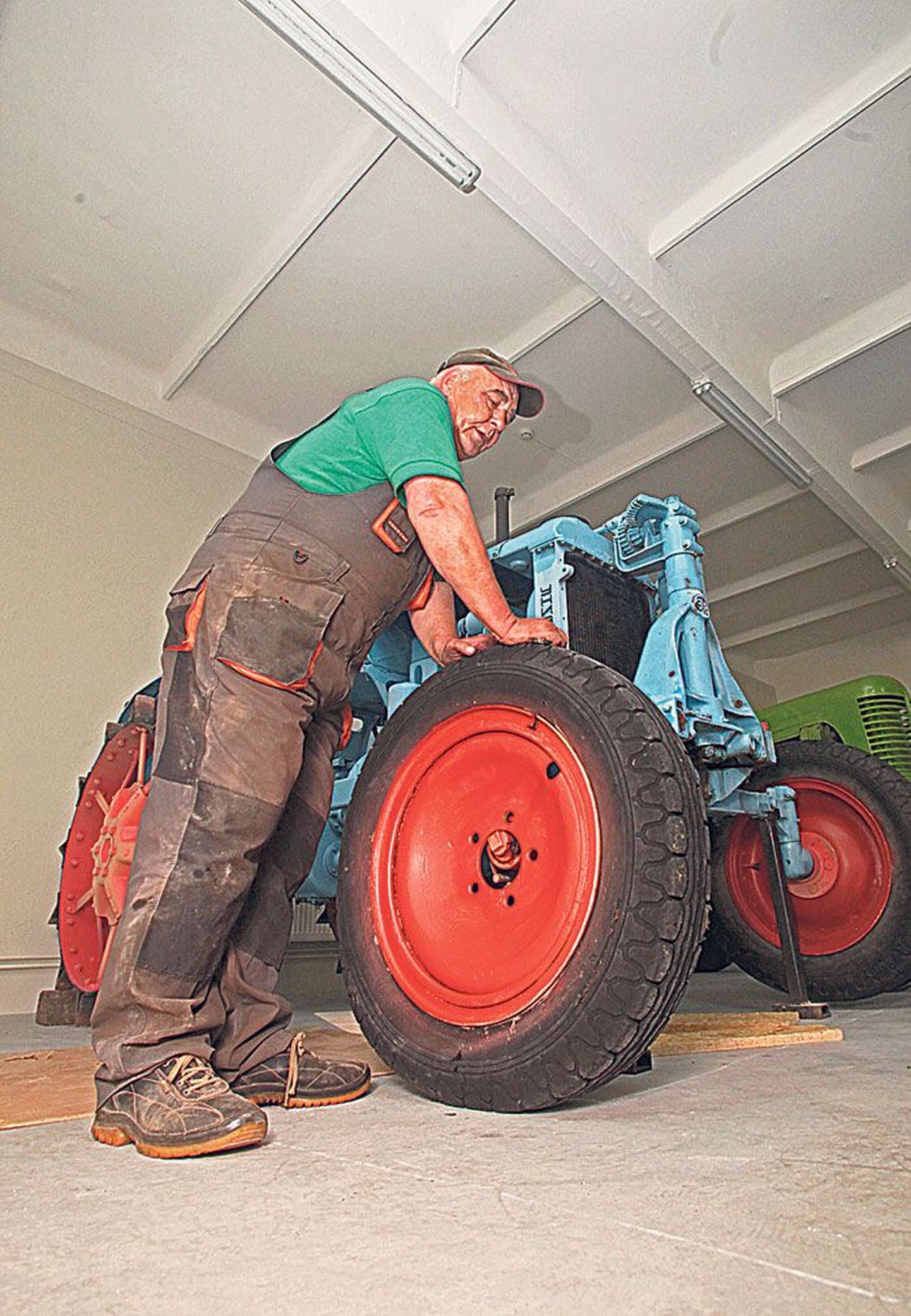Eesti Põllumajandusmuuseumi restauraator-mehaanik Kalju Tenn paneb ratta alla ühele 1950. aastatest pärit eksponaadile, Vene vaheltharimistraktorile Universal.
