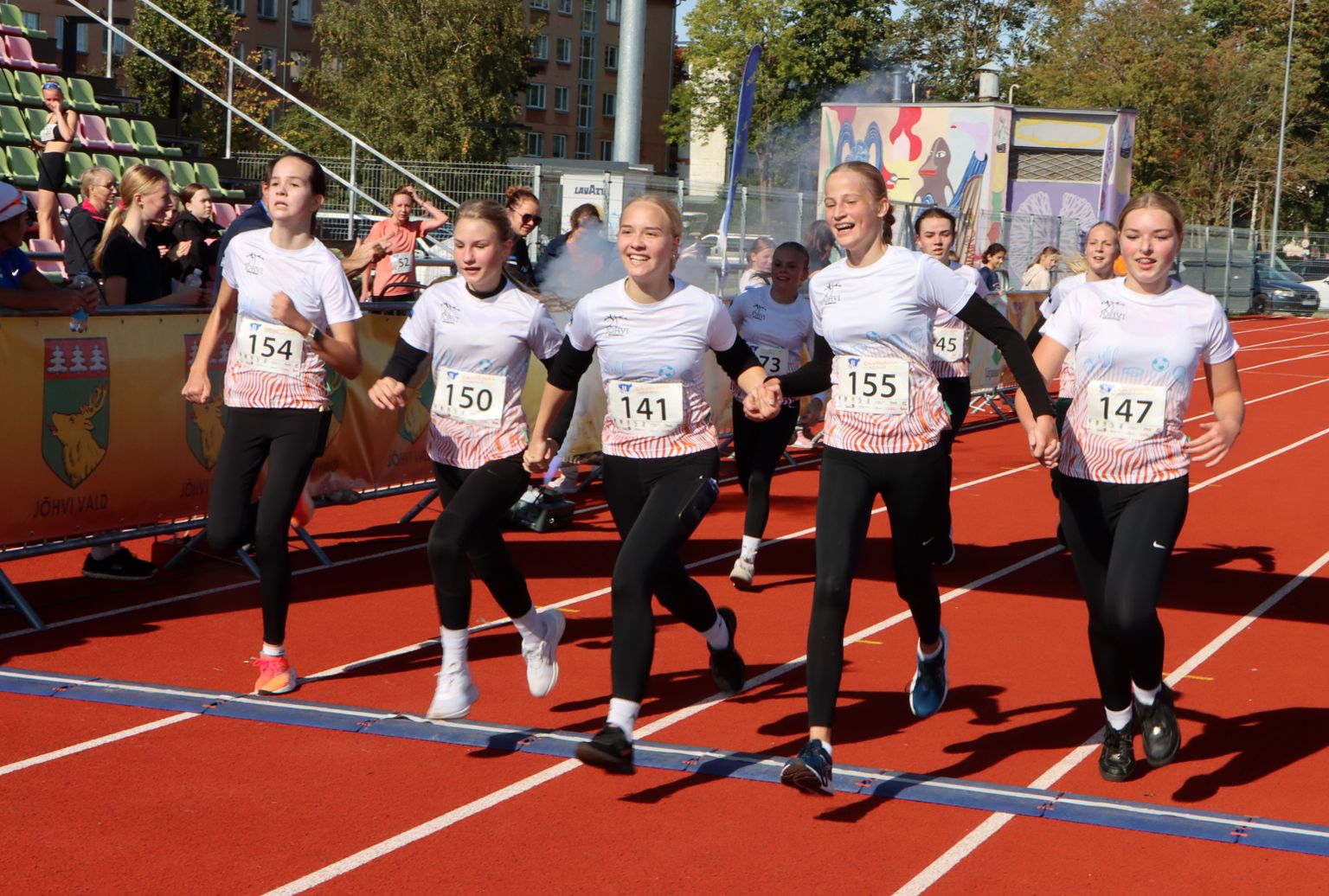 Üheskoos rõõmsalt jõuavad üle 5 km jooksu lõpujoone Jõhvi spordikooli tüdrukud.