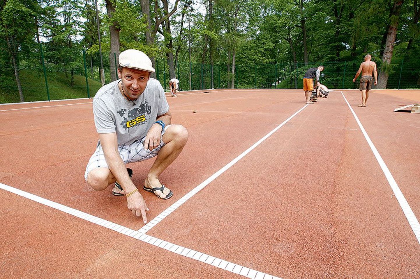OÜ Toome Tennis juhatuse liige Juhan Peedimaa näitab uue tenniseväljaku jooni, mis kleebitakse tugevalt väljakukatte külge. «Need ei liigu paigast ära ja nende taha ei jää jalg kinni,» sõnas Peedimaa.