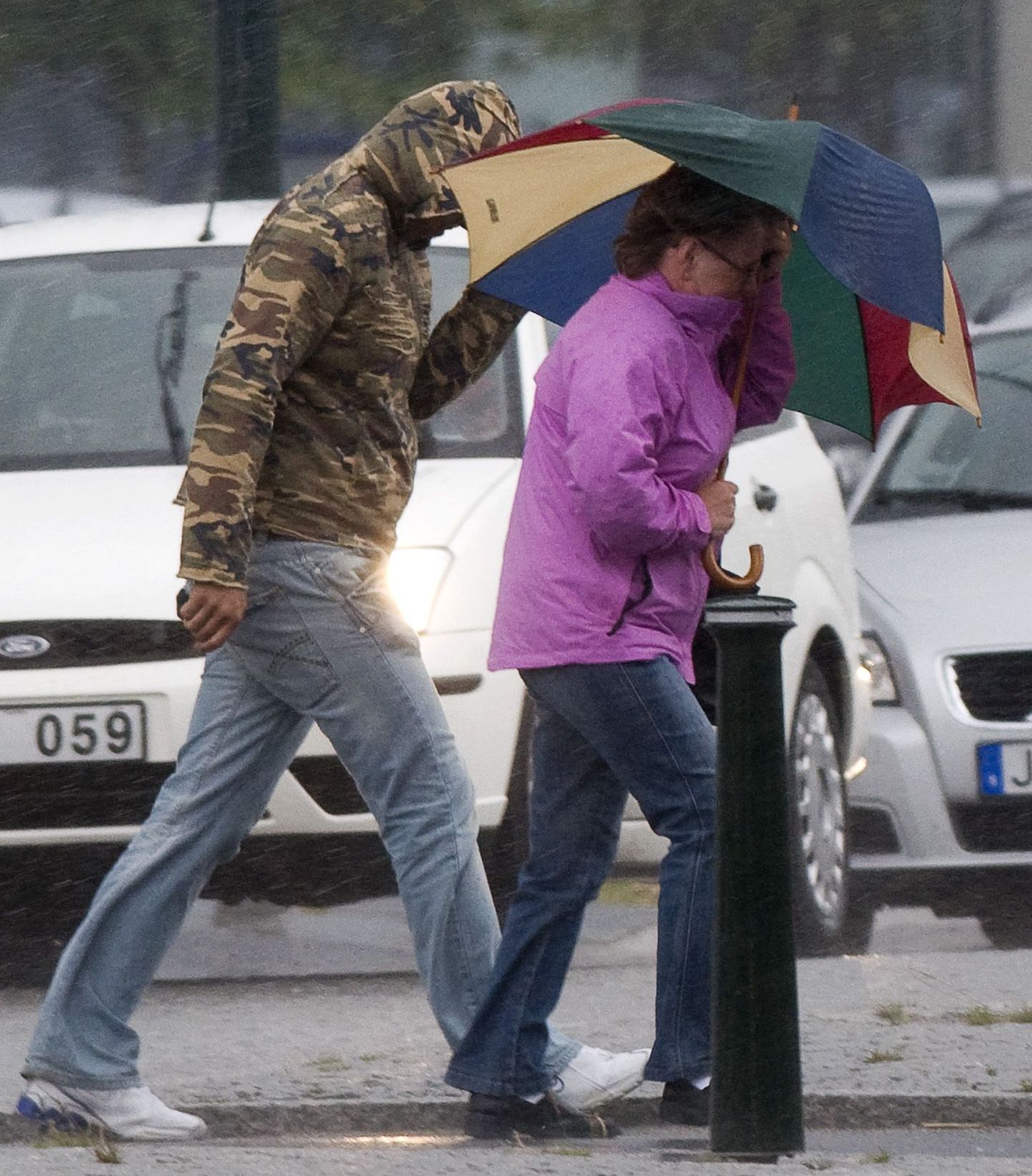 Inimesed võitlevad tormituule ja vihmaga Malmö tänaval.