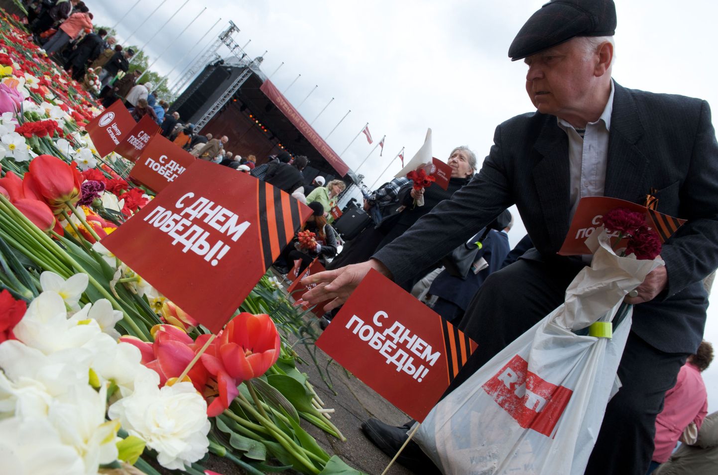 Vene veteranid asetamas lilli Riia võidumonumendi juurde.