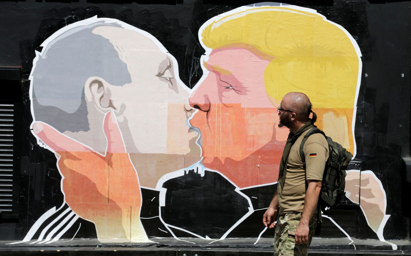 A man walks past a graffiti depicting U.S. Republican presidential Donald Trump (R) and Russia's President Vladimir Putin in Vilnius, Lithuania, June 1, 2016. REUTERS/Ints Kalnins   FOR EDITORIAL USE ONLY. NO RESALES. NO ARCHIVES
