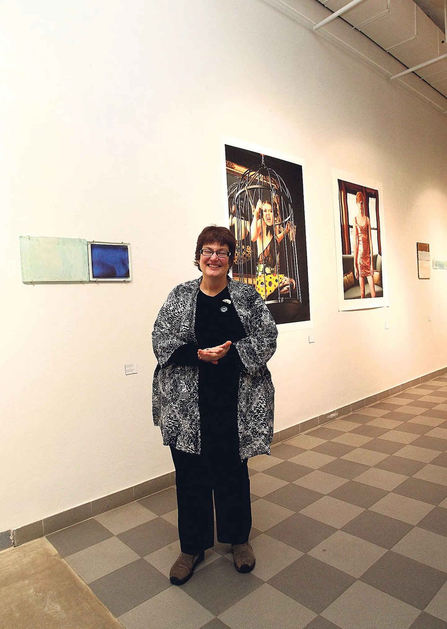 Tartu kõrgema kunstikooli galerii Noorus suures saalis on Mary Jane Gregory paremal käel tema maalid klaasil ja selja taga tema õe Barbara Nitke fotod.