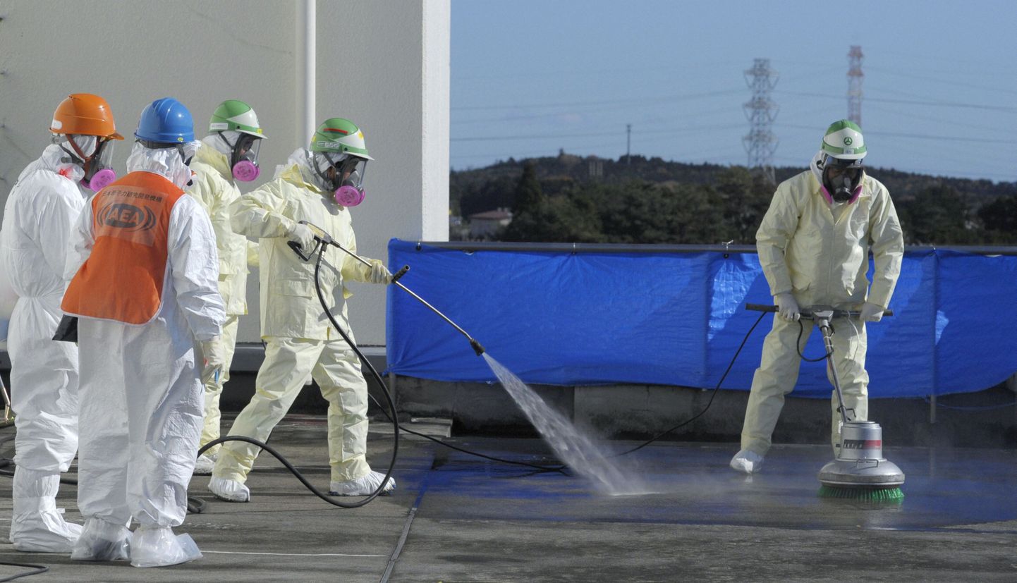 Jaapani töölised Fukushima lähedal asuvas Okuma linnas hoone katust saastumisest puhastamas.