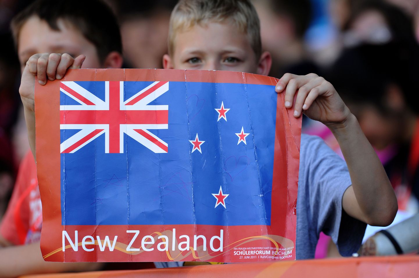 Poiss näitab paberile trükitud Uus-Meremaa lippu.