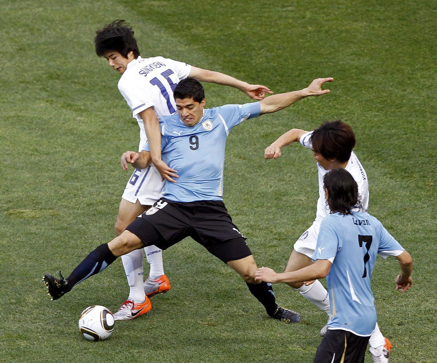 Луис Суарес в борьбе за мяч с игроками Южной Кореи.