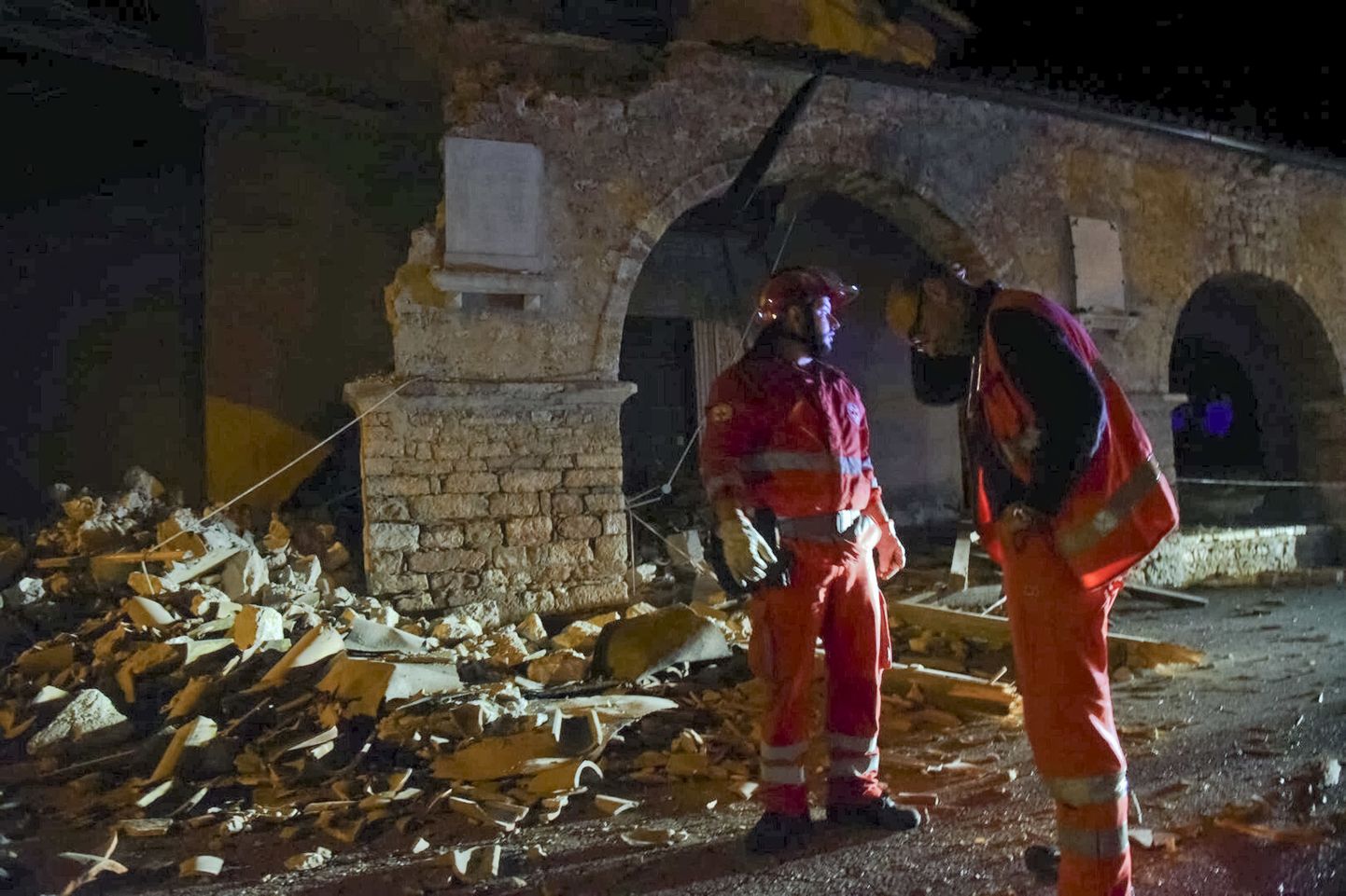 Rescuers stand by rubble in the village of Visso, central Italy, Wednesday, Oct. 26, 2016 following an earthquake. A pair of powerful aftershocks shook central Italy on Wednesday, knocking out power, closing a major highway and sending panicked residents into the rain-drenched streets just two months after a powerful earthquake killed nearly 300 people. (Matteo Crocchioni/ANSA via AP)