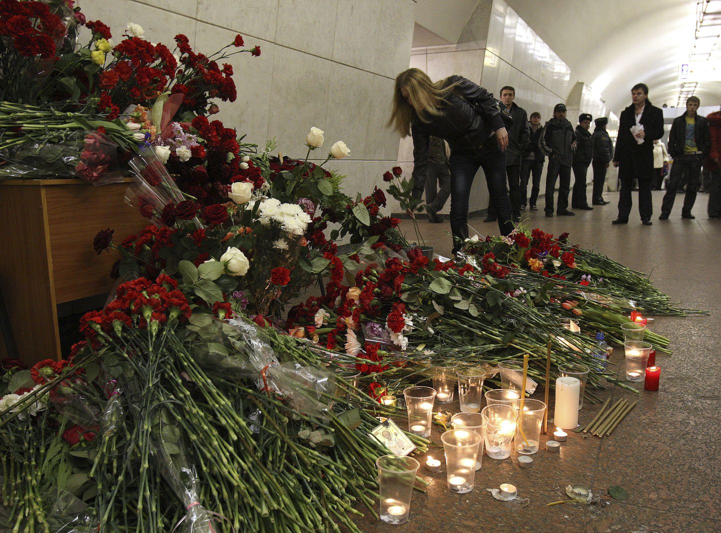 Жители Москвы приносят цветы на место трагедии.