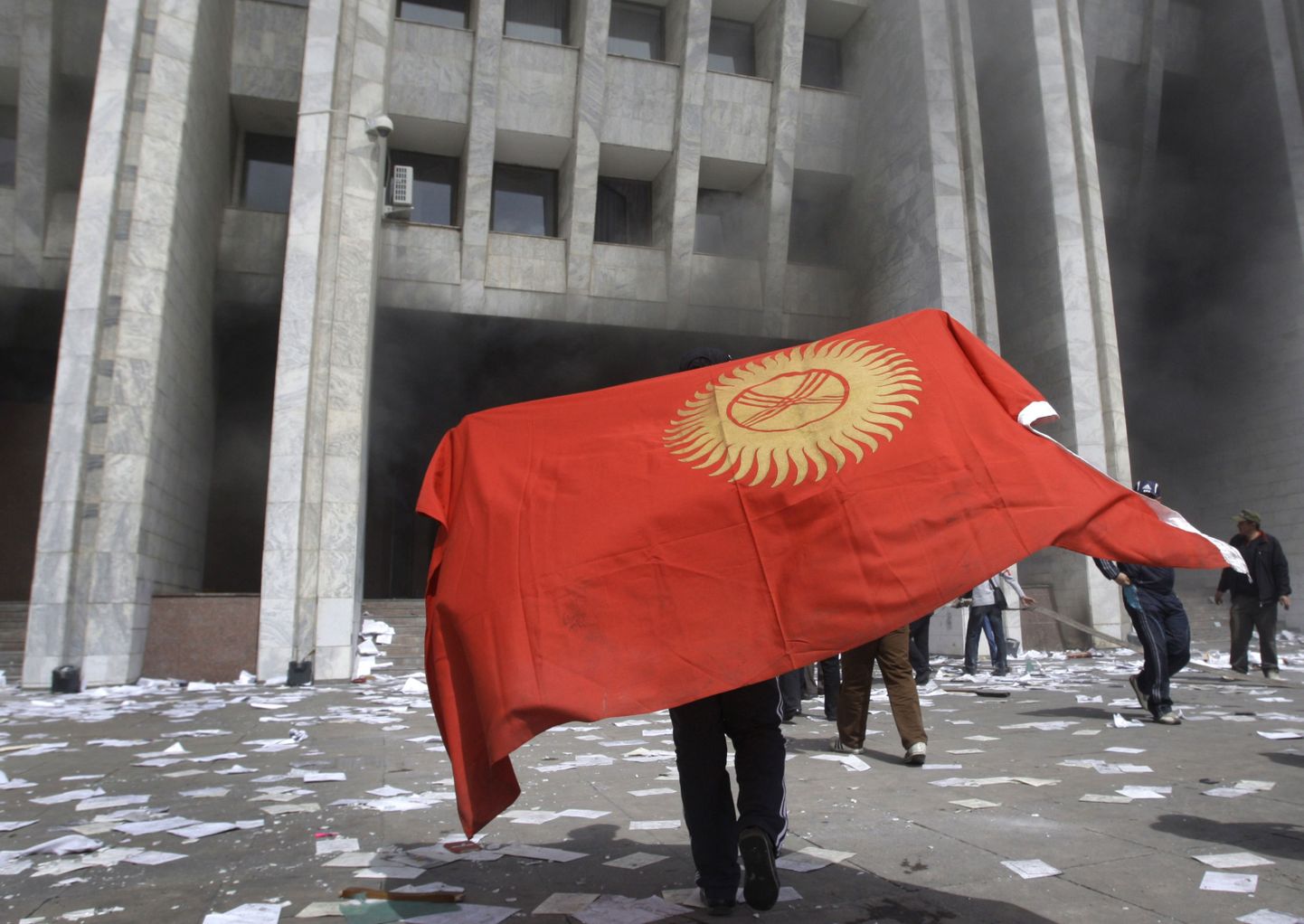 Meeleavaldaja kannab Kõrgõzstani rahvuslippu valitsushoone ees Biškekis.