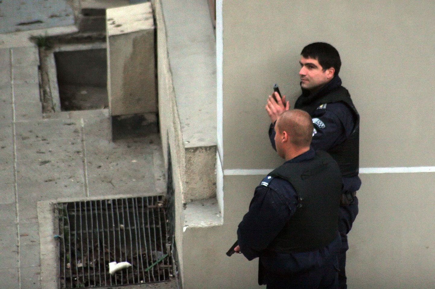 Полицейские стоят неподалеку от здания банка, в котором грабитель захватил заложников.