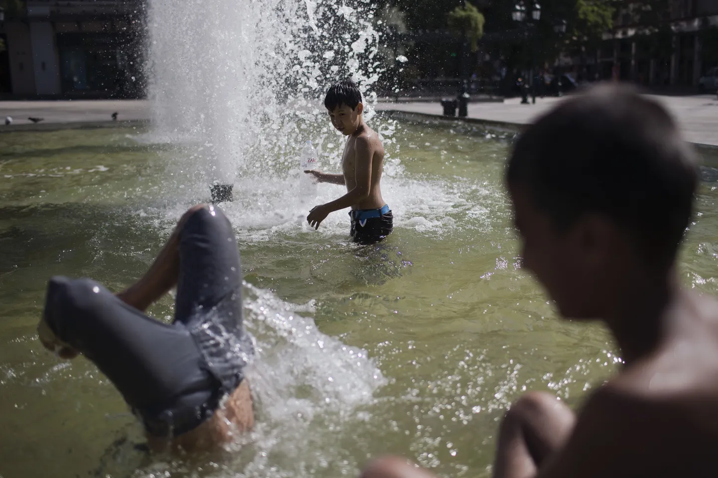 Афины. Дети спасаются от жары в фонтане.