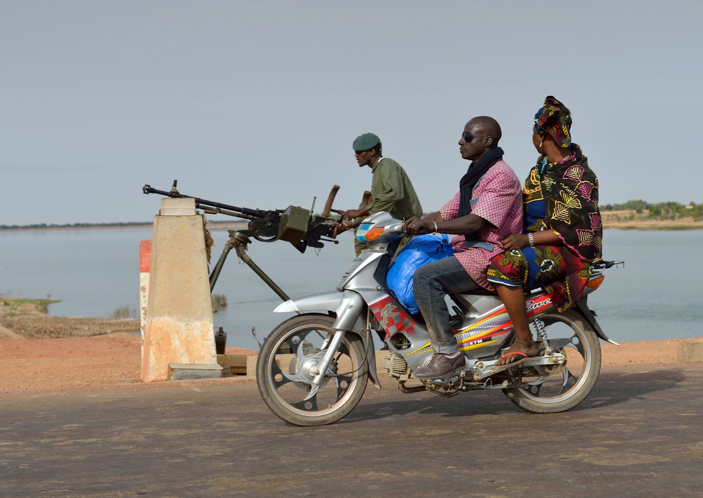 Mees ja naine mopeedil möödumas Mali sõdurist Markala linna lähedal.
