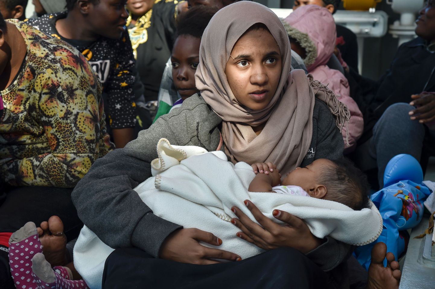 Noor naine põgenikepaadis last hoidmas.