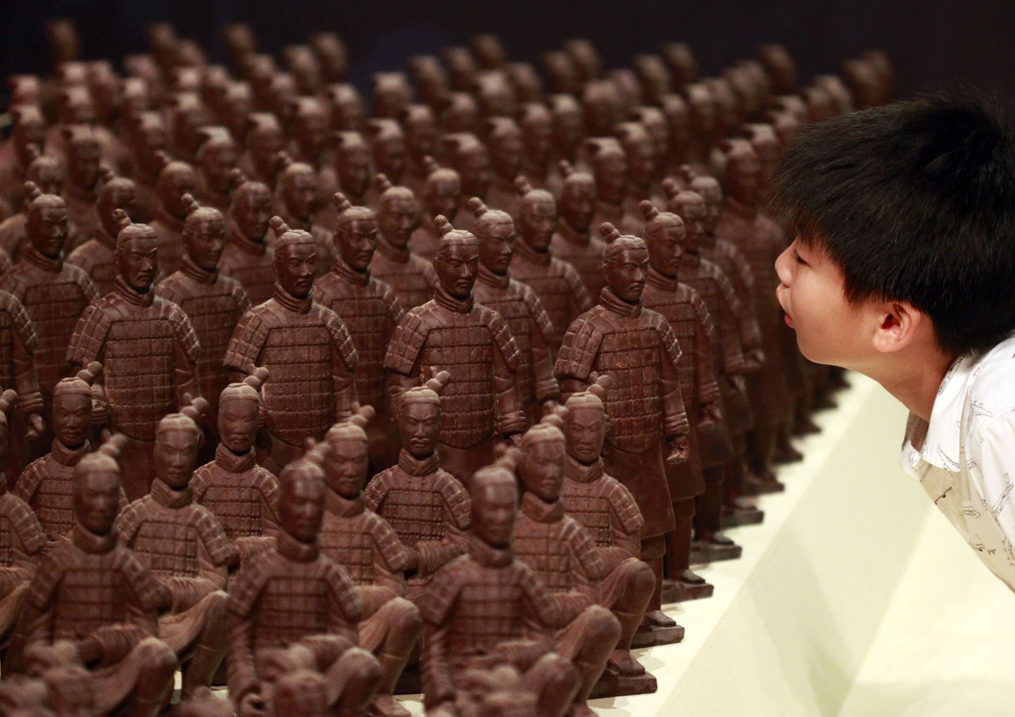 Väike poiss uudistab šokolaadist terrakotasõdalasi