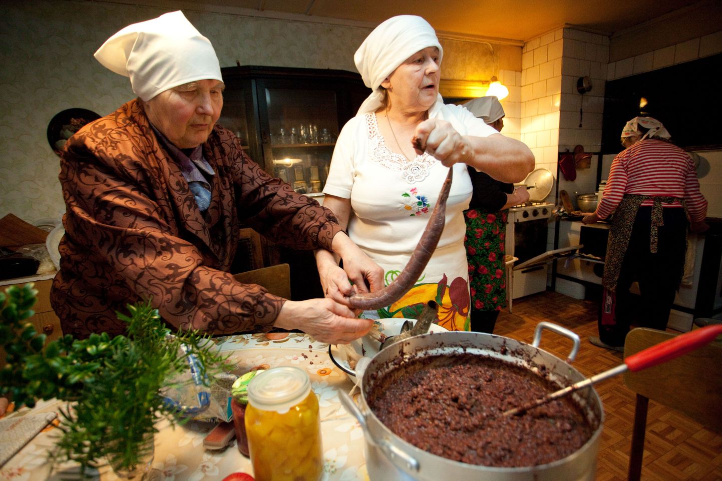 Pensionär Maret Suviste (vasakul) ja Uhtna naisseltsingu juht Helle Pikkoja täidavad seasooled verivorstipudruga.