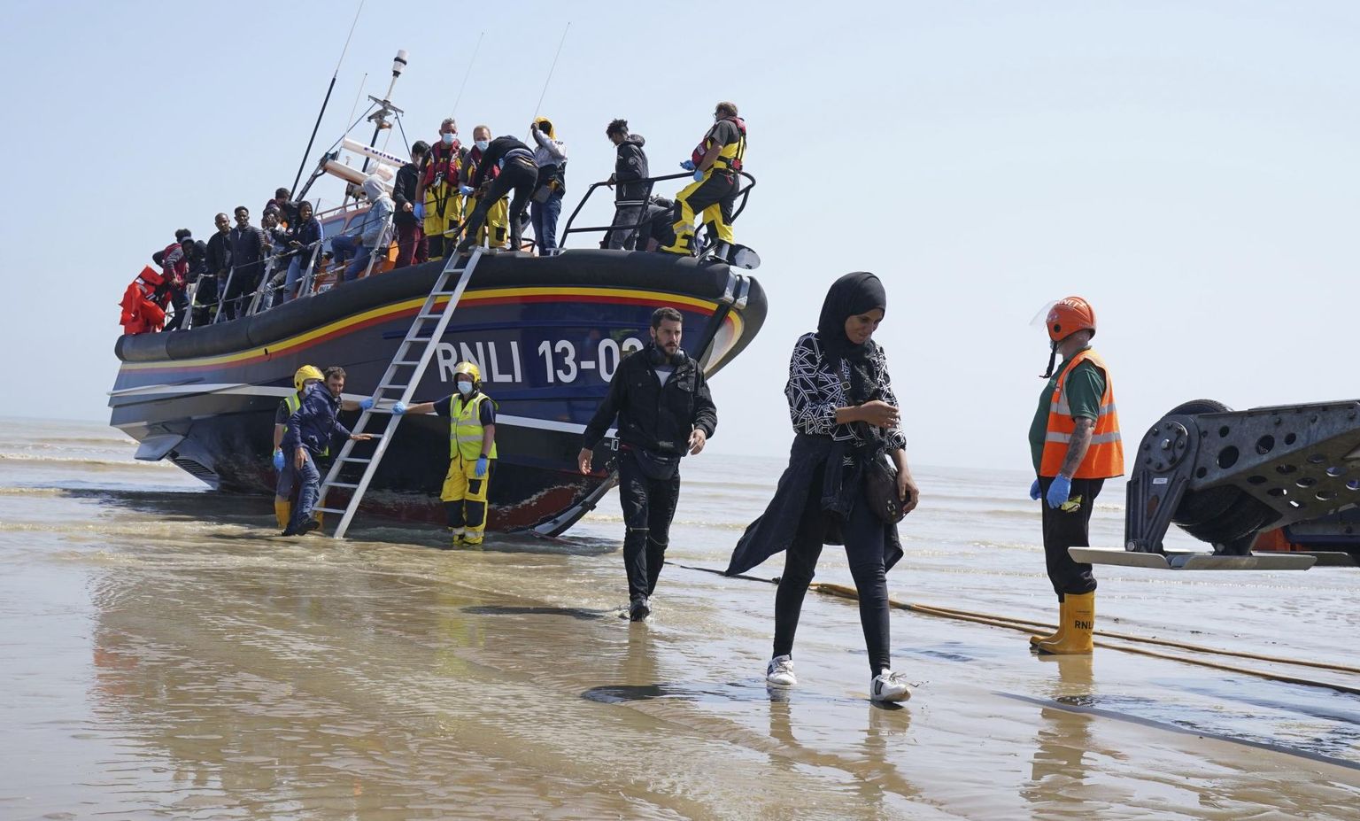 La Manche’i väinas päästetud migrandid astuvad Dungenessis päästepaadilt Suurbritannia pinnale. Briti valitsus sooviks tulevikus asüülitaotlejad taotluste menetlemiseks kolmandasse riiki toimetada.