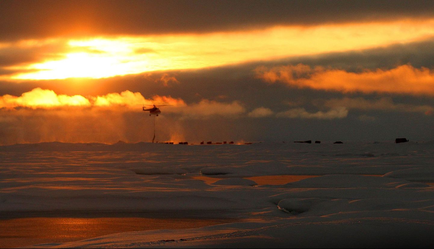Päikeseloojang ja helikopter Arktikas.