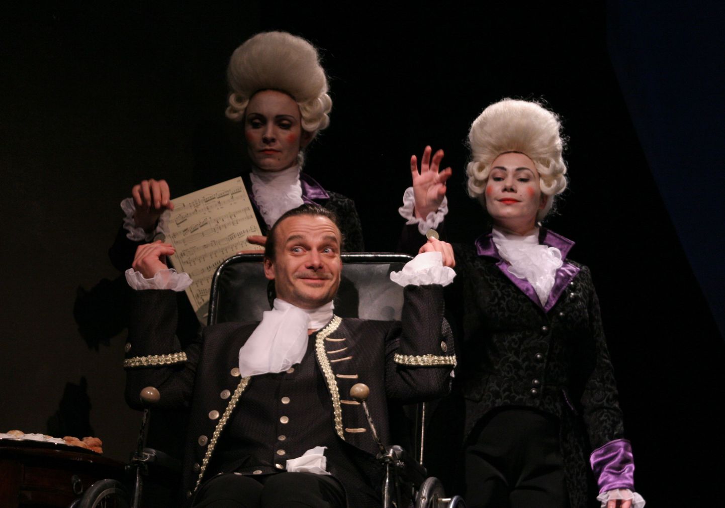 Stseen lavastusest «Amadeus», esiplaanil Salieri - Indrek Sammul, tema
taga Venticellod - Triinu Meriste ja Kata-Riina Luide.