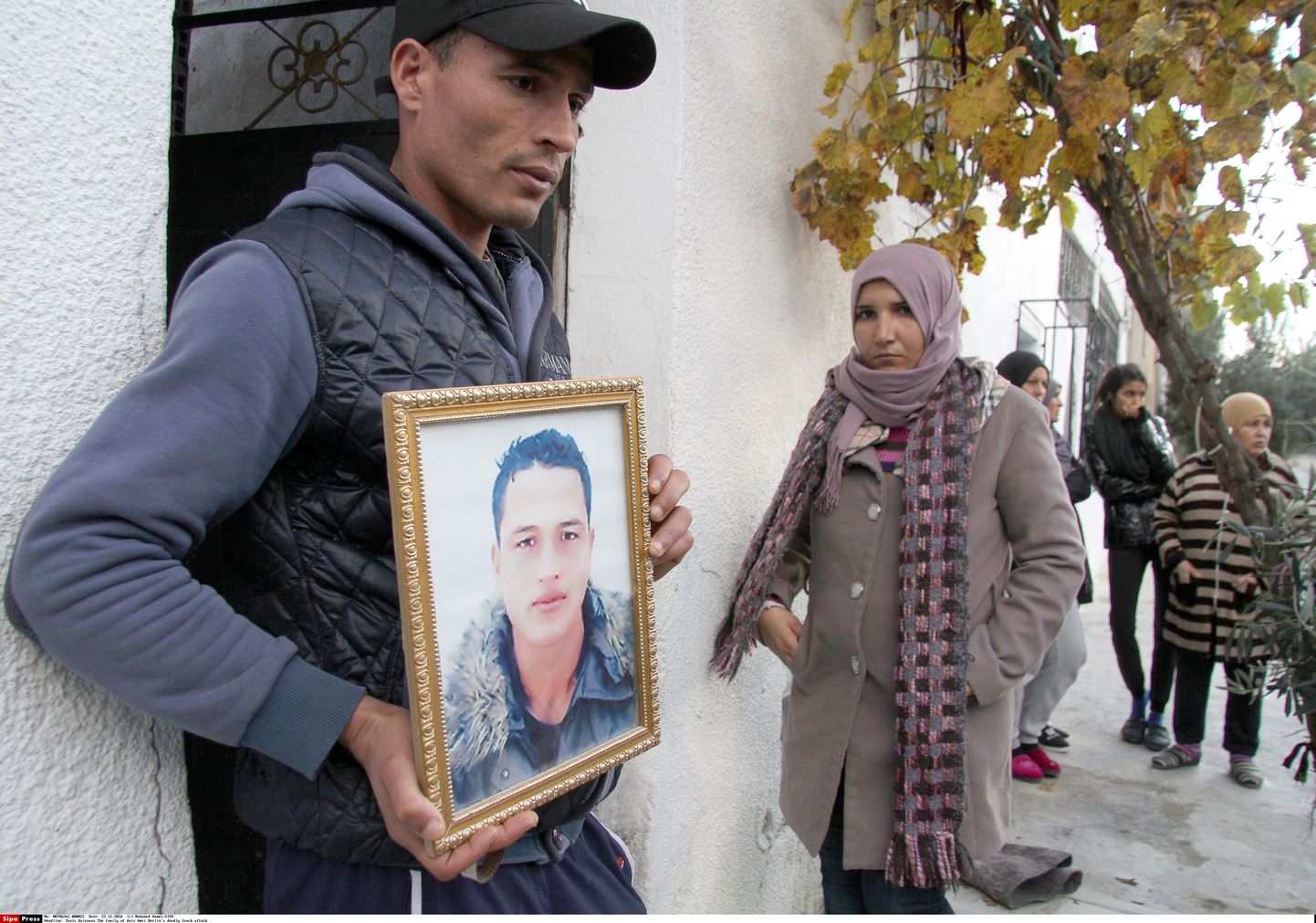 Anis Amri vend Walid hoiab käes väidetavalt Berliini jõuluturul terrorirünnaku korraldanud Anisi raamitud portreepilti oma kodumaja ees Tuneesias, Oueslatia linnas.