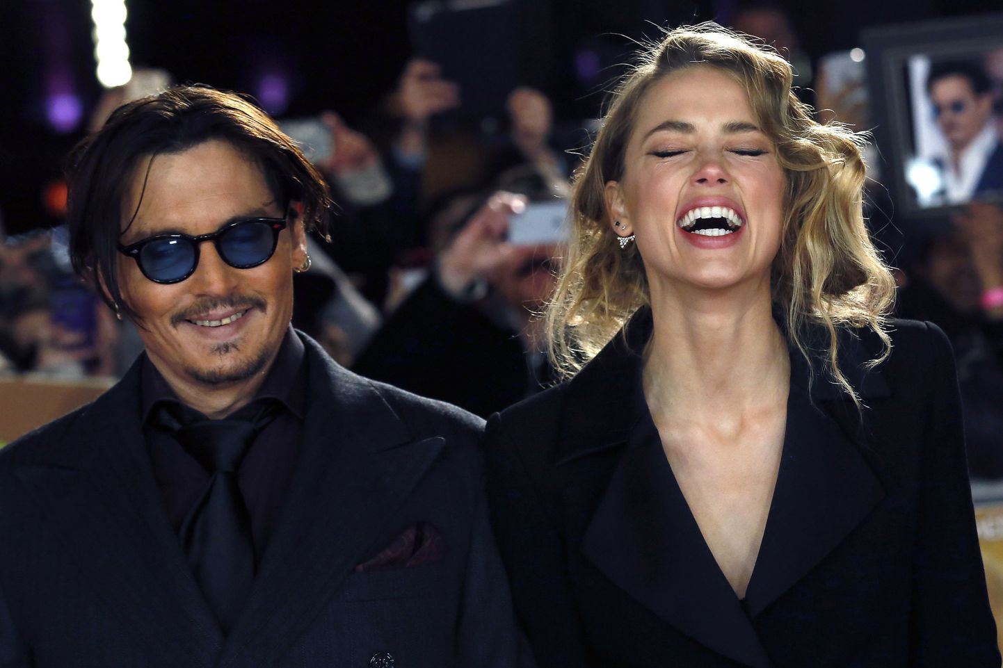 Actor Johnny Depp and girlfriend Amber Heard laugh as they arrive for the UK premiere of "Mortdecai" at Leicester Sqaure in London, in this file photo taken January 19, 2015.  Depp, the star of the "Pirates of the Caribbean" film series, married his fiancee, Amber Heard, at their home in Los Angeles earlier this week, according to People magazine.  REUTERS/Luke MacGregor/Files   (BRITAIN - Tags: ENTERTAINMENT)