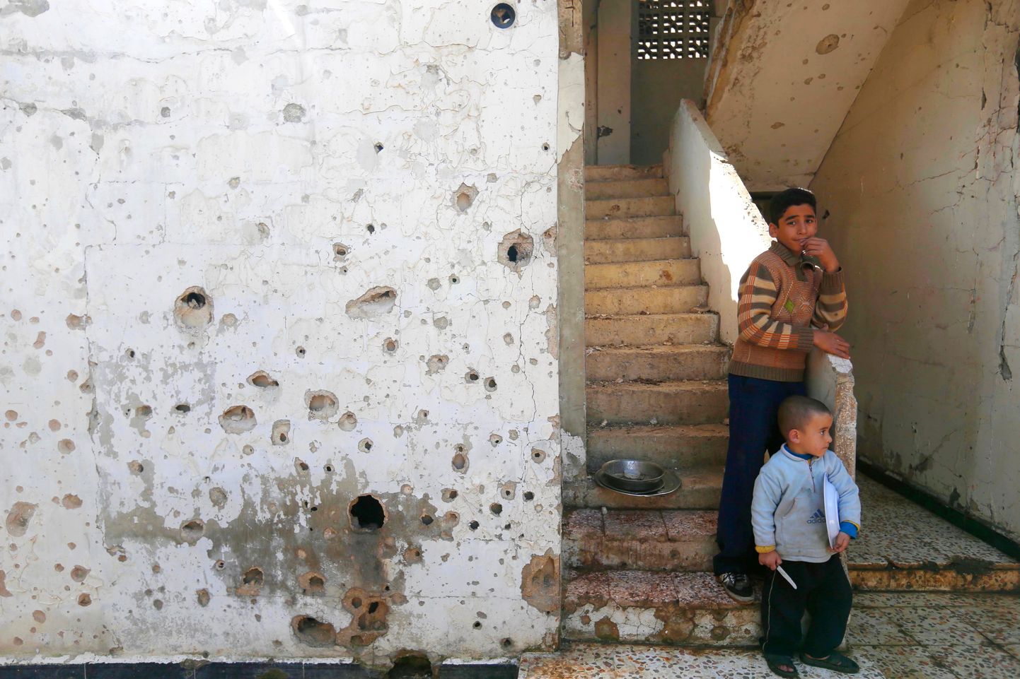 Süüria poisid oma hävitatud kodumaja ees Homsi linnas.