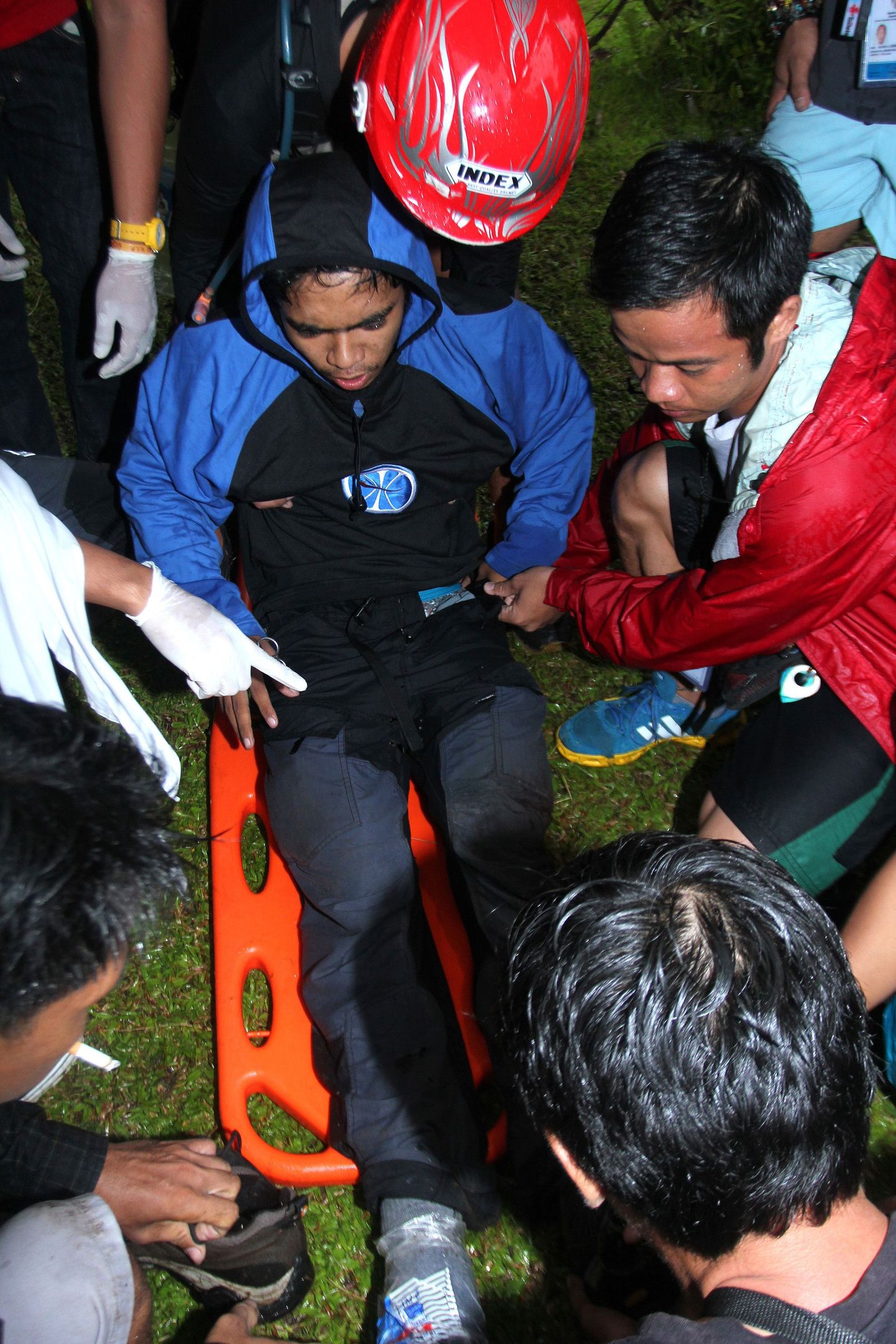 Päästetöötajad aitavad Mayoni mäel viga saanud giidi Nicanor Mabaod.
