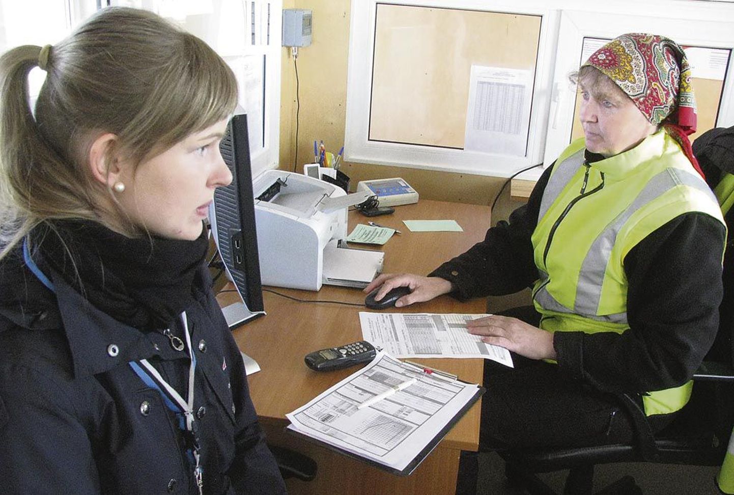 Lennuki kapten Elise Ots ja Kihnu lennujaama operaator Helje Saare täidavad viimase stardi eel dokumente.