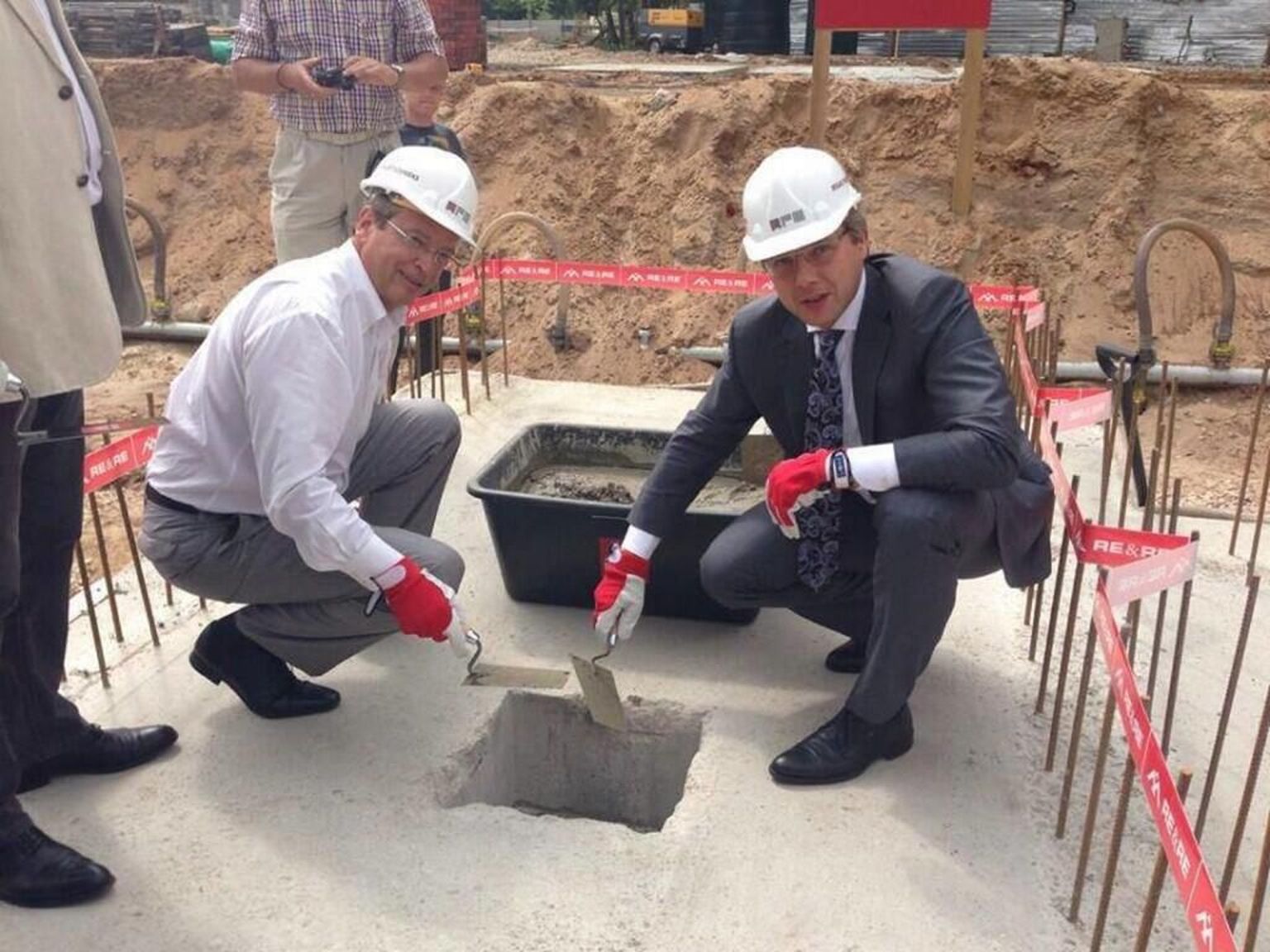 Läti ehitusfirma Re&Re lintidega piiratud ehitusplatsilt pani Riia Zolitūde ostukeskusele nurgakivi linnapea Nils Ušakovs (paremal).