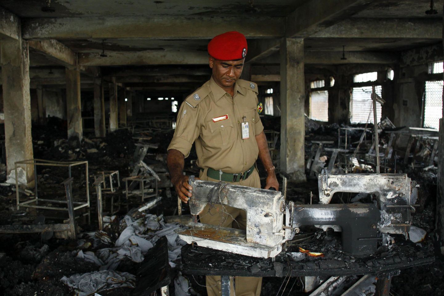 Bangladeshi ametnikud uurimas Gazipuri linnas põlenud riidevabriku sisemust.