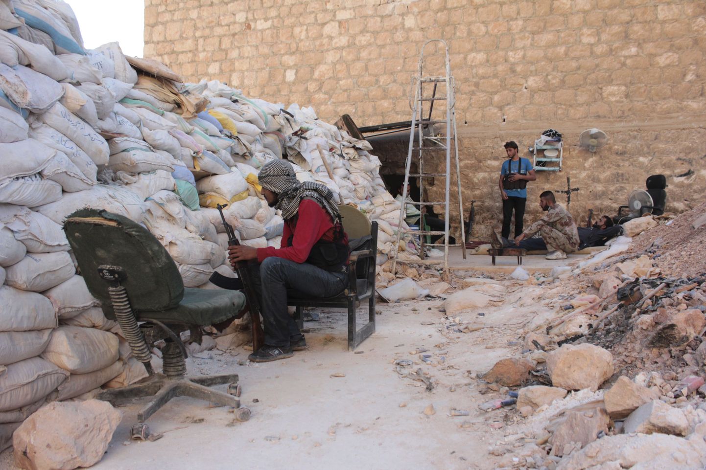 Vaba Süüria Armee sõdur istub koos relvaga liivakottidest ehitatud kaitsemüüri taga Aleppo lähistel  al-Khalidiyas.
