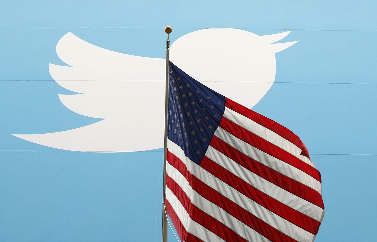 Twitteri logo Ühendriikide lipu taustal.