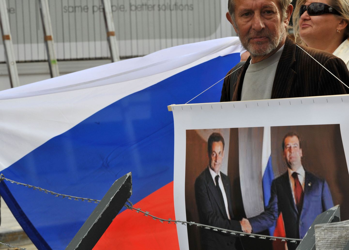 Русский участник акции протеста в Брюсселе с фотографией президента Франции Николя Саркози и президента России Дмитрия Медведева после войны в Грузии. Как утверждают, за участие в подобных уличных мероприятиях некоторым демонстрантам платят деньги.