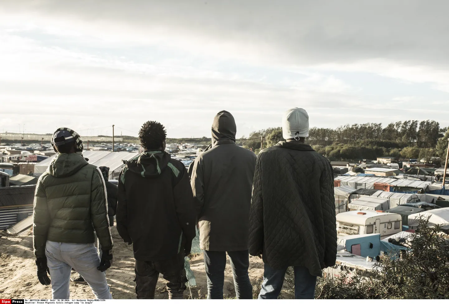Lammutatud Calais põgenikelaagri elanikud, Sudaanist ja Eritreast pärit noored mehed vaatavad ikka Suurbritannia suunas.