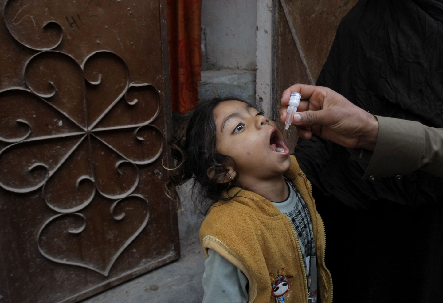 Pakistani tervishoiutöötaja vaktsineerimas last